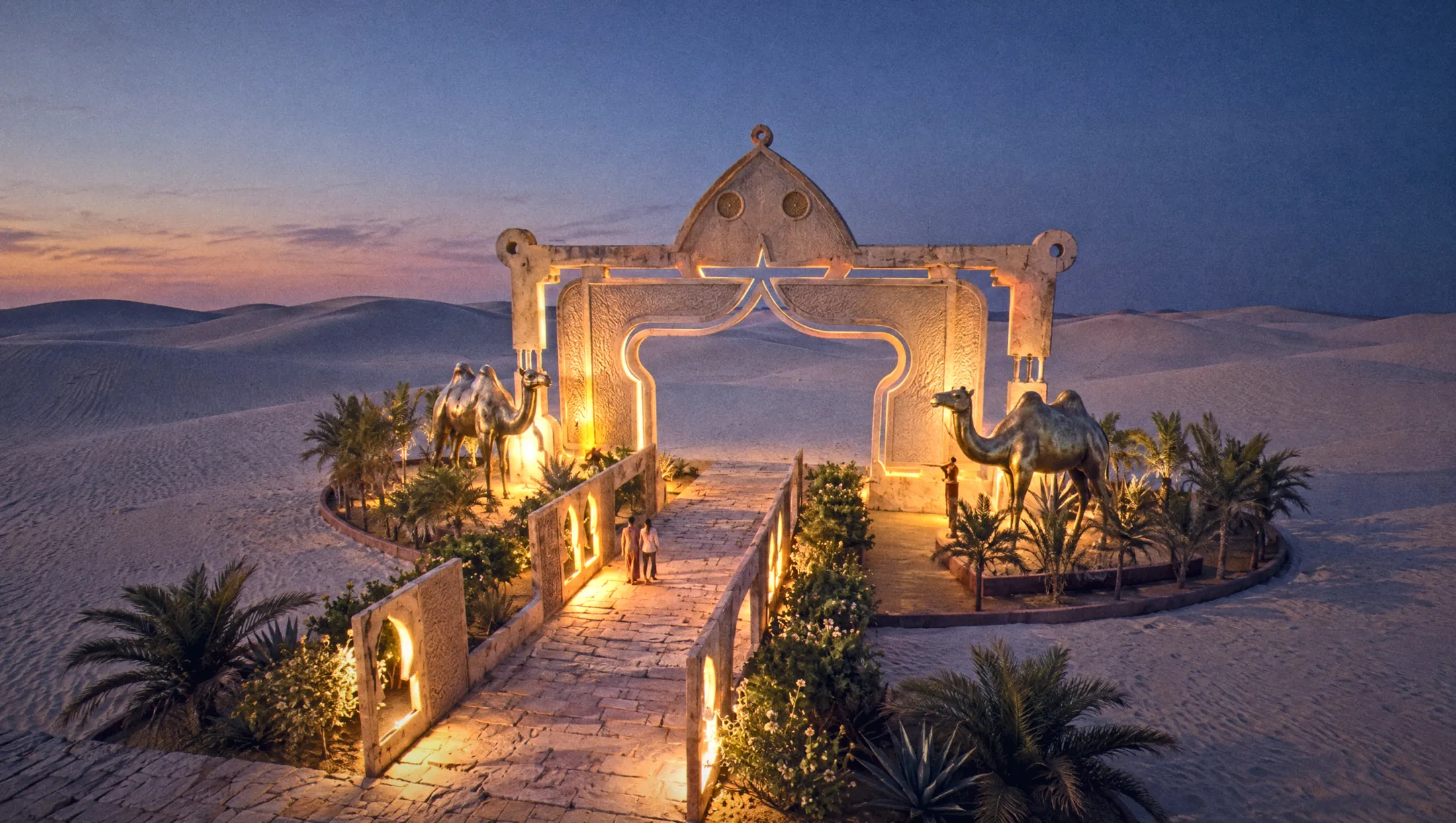 Sculpted plaster horseshoe arch with bronze camels, lit at blue hour among the dunes